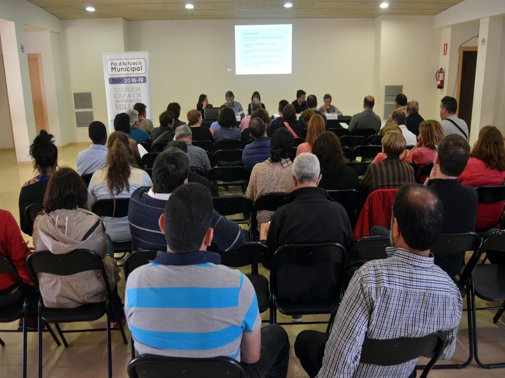 Sala de conferències amb l'audiència d'esquenes i imatge projectada al davant