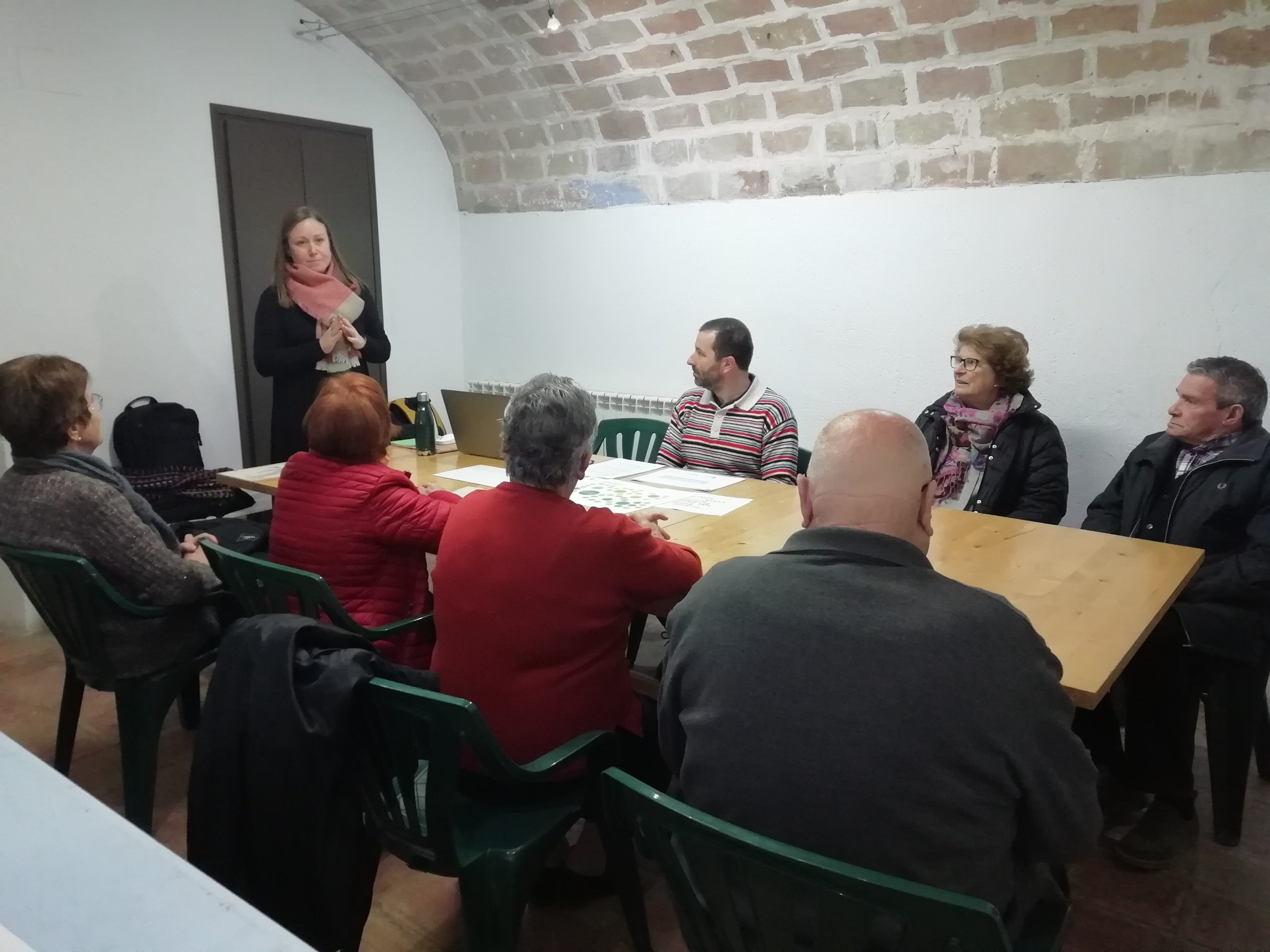 Pla municipal de la gent gran: Aula formativa amb persones assegudes en cercle i la formadora de peu