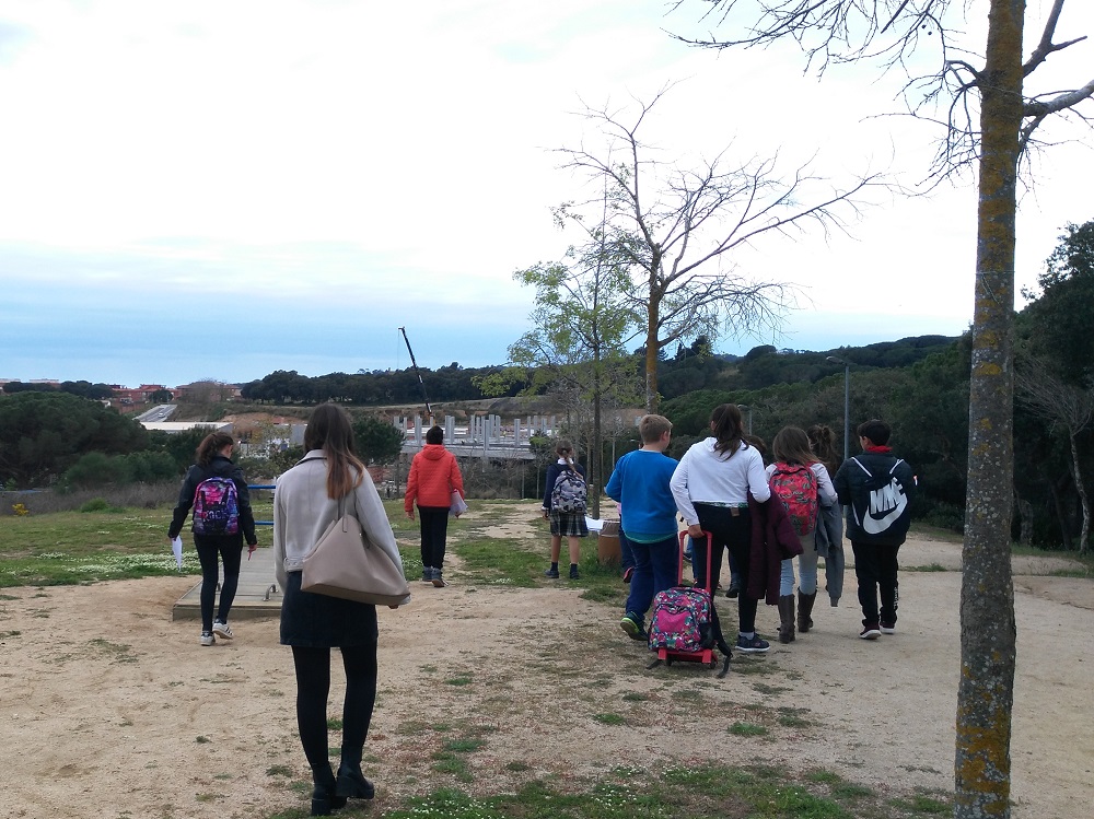 Jovent caminan d'esquenes en un parc