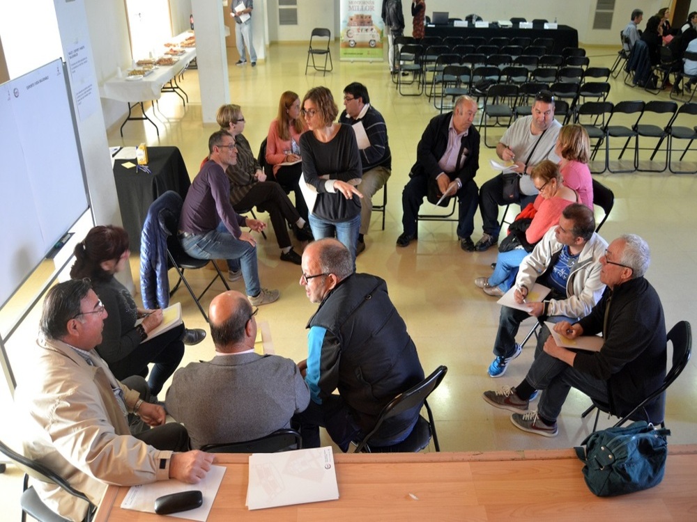 Grup de persones assegudes en cercle amb la formadora al mig